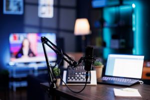 Gros plan sur un microphone professionnel et un ordinateur portable dans un studio moderne pour l'enregistrement d'un podcast à Paris
