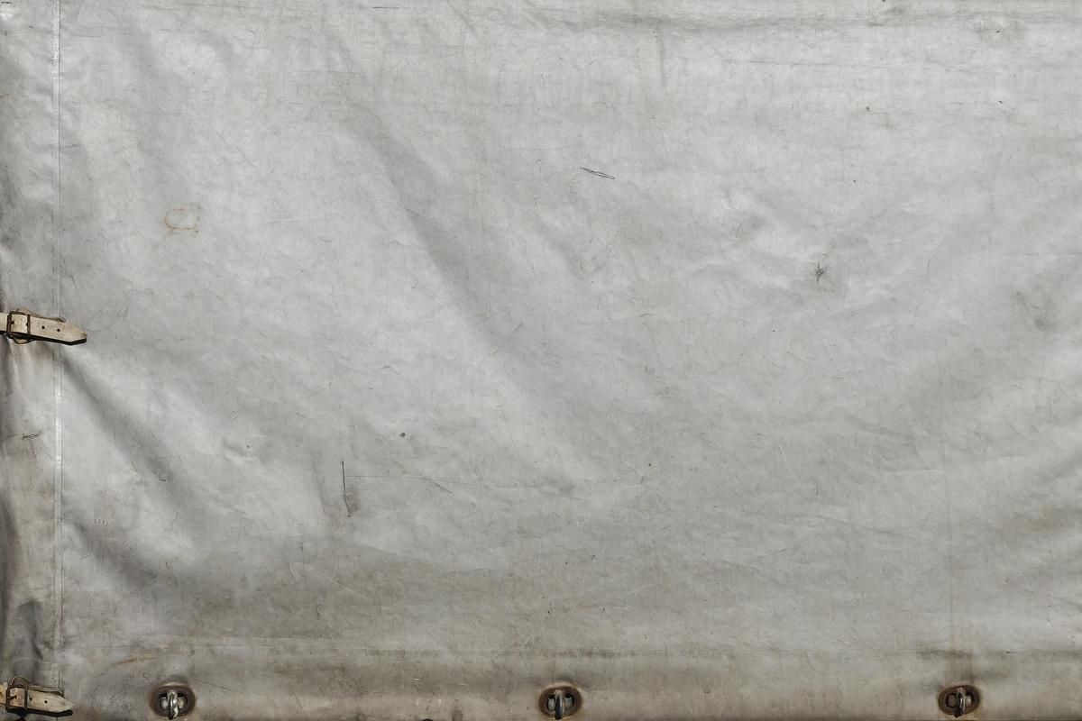 Tissu gris usé avec attaches métalliques et coutures visibles