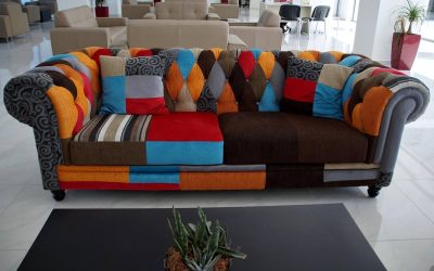 Canapé coloré aux motifs patchwork, table basse noire, plante, intérieur moderne