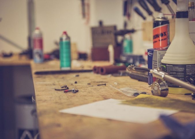 Table de travail en bois avec outils sprays lampe et papier