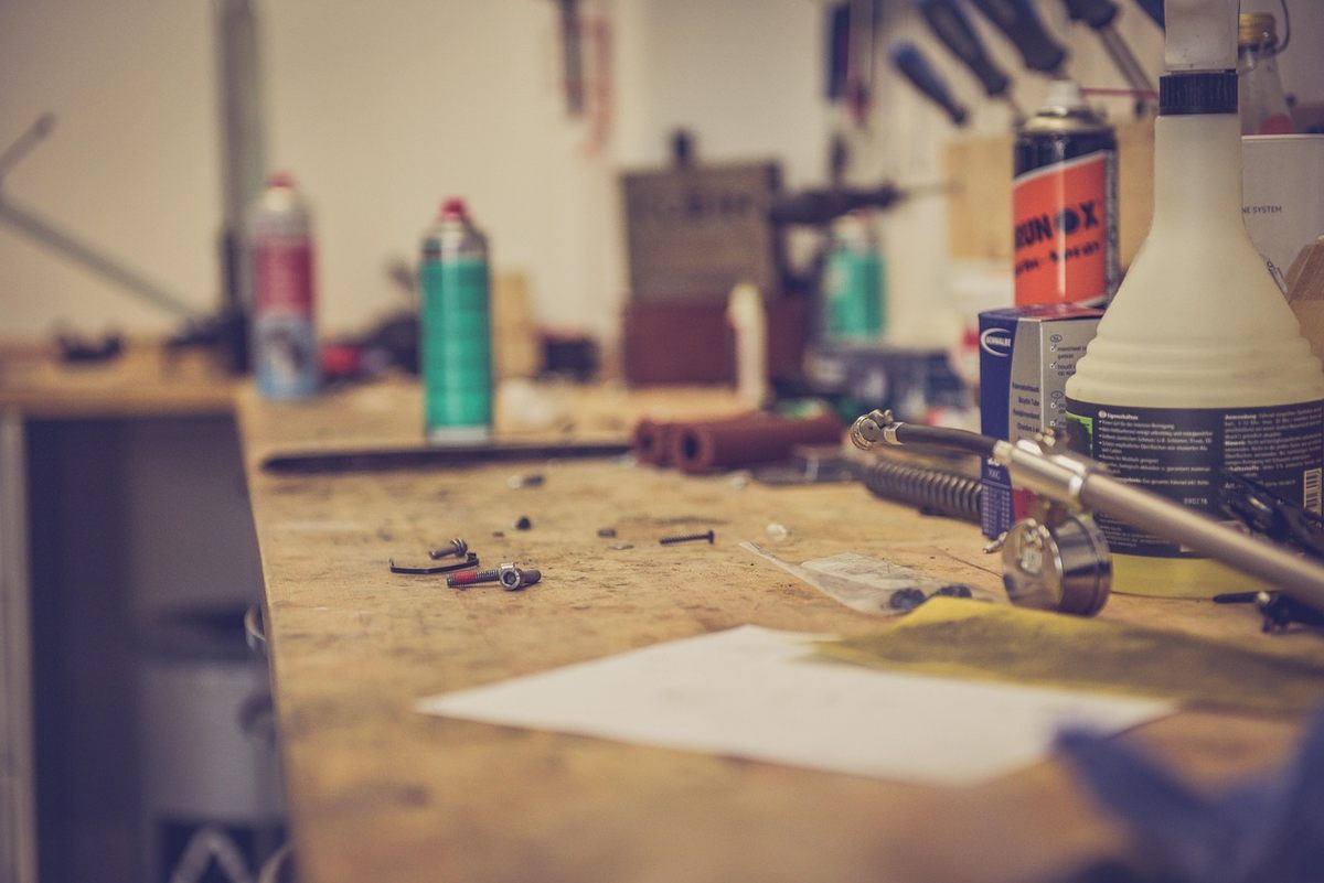 Table de travail en bois avec outils sprays lampe et papier