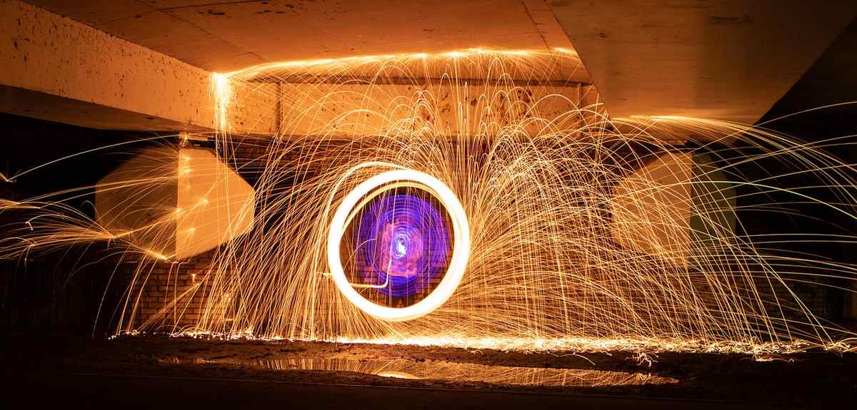 Des étincelles entourent une roue circulaire brillante sous un plafond Des étincelles entourent une roue circulaire brillante sous un plafond