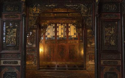 Porte en bois sculptée, panneaux décorés, lumière chaleureuse, intérieur traditionnel