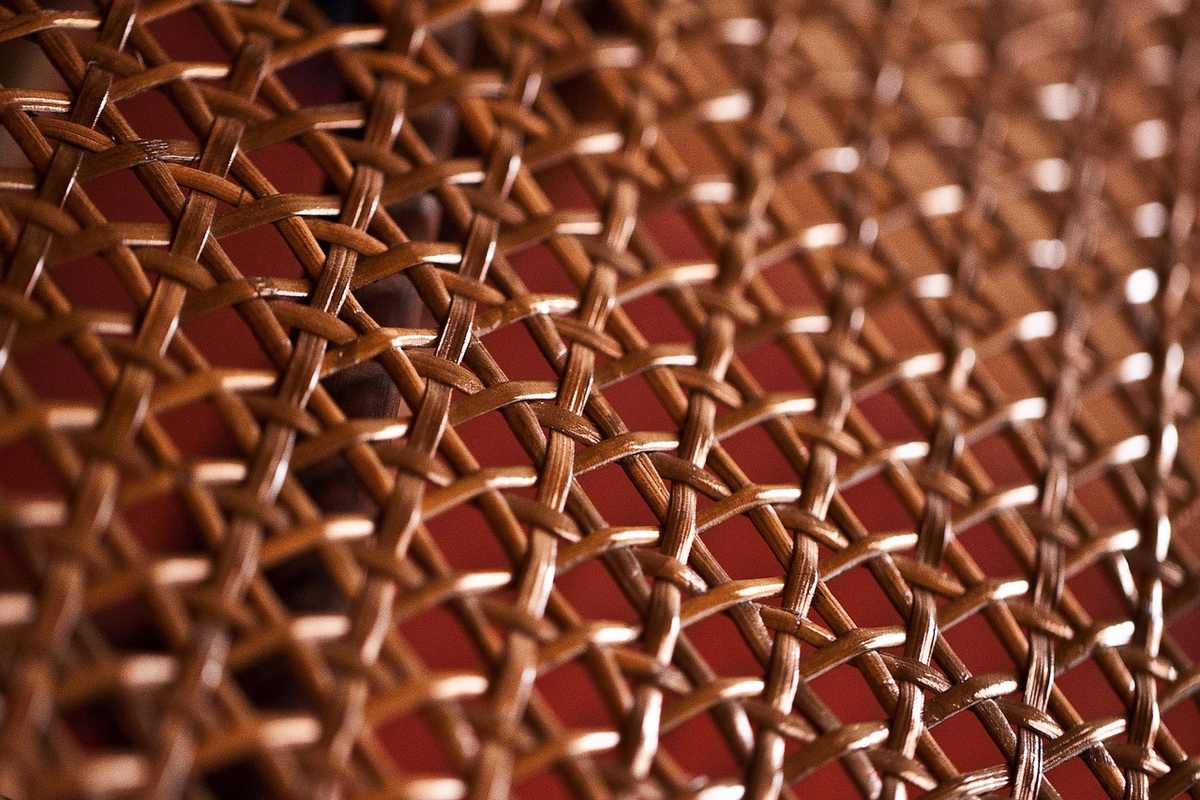 Motif en rotin tressé sur fond rougeâtre texture détaillée